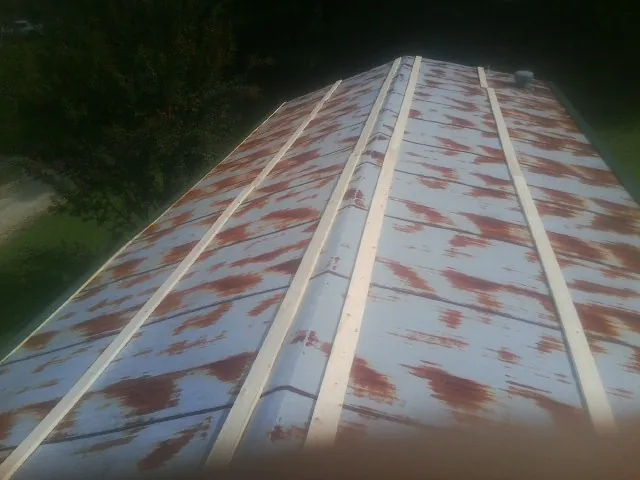 Rusted metal roof panels with new wood purlins before replacement — Storm Damage Roof Repair in Centerview by Roofing Brothers