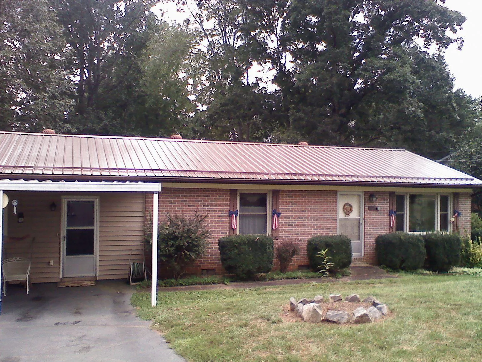 Bronze metal roof and carport on a brick ranch home — Roof Repair work by our crew in Centerview